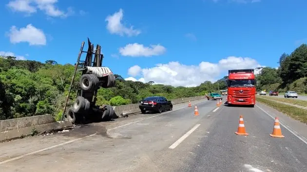 Carreta despenca de 10 metros após invadir pista contrária e bater em carro; três pessoas ficaram feridas