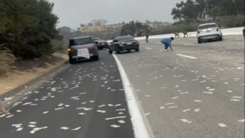 Estrada congestiona com chuva de dinheiro, após porta de caminhão blindado se abrir