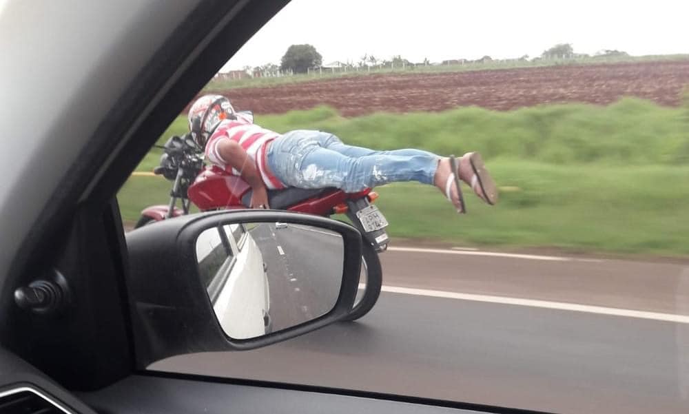 Um motociclista foi fotografado enquanto pilotava uma moto deitado sobre ela na BR-376