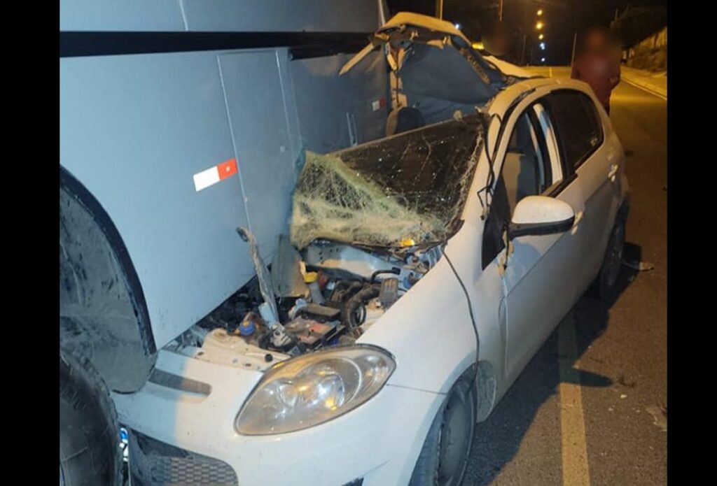 Carro atinge traseira de ônibus estacionado na principal avenida de Mallet e fica destruído