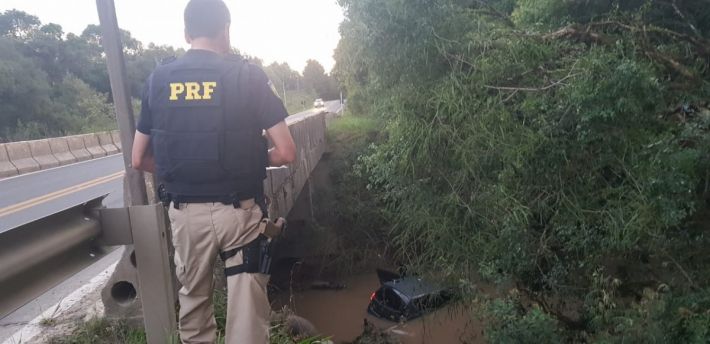 Carro colide em proteção de pista e cai em rio em Rio Azul